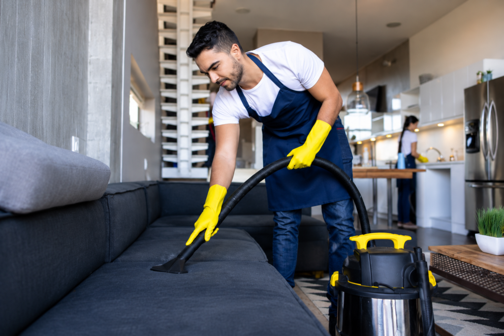 Professional sofa cleaning service using an upholstery extraction machine.